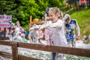 An image of a girl extremely happy to be messy and playing with foam.