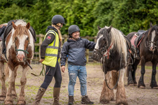 An image of a man thanking the horse for the ride with a big smile on his face.